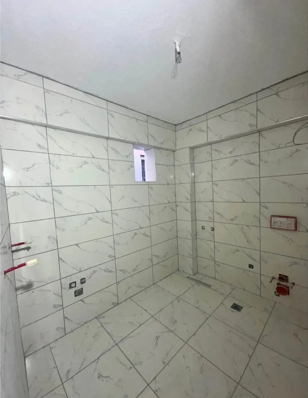 Beyaz mermer desenli duvar ve zemin fayanslı banyo
