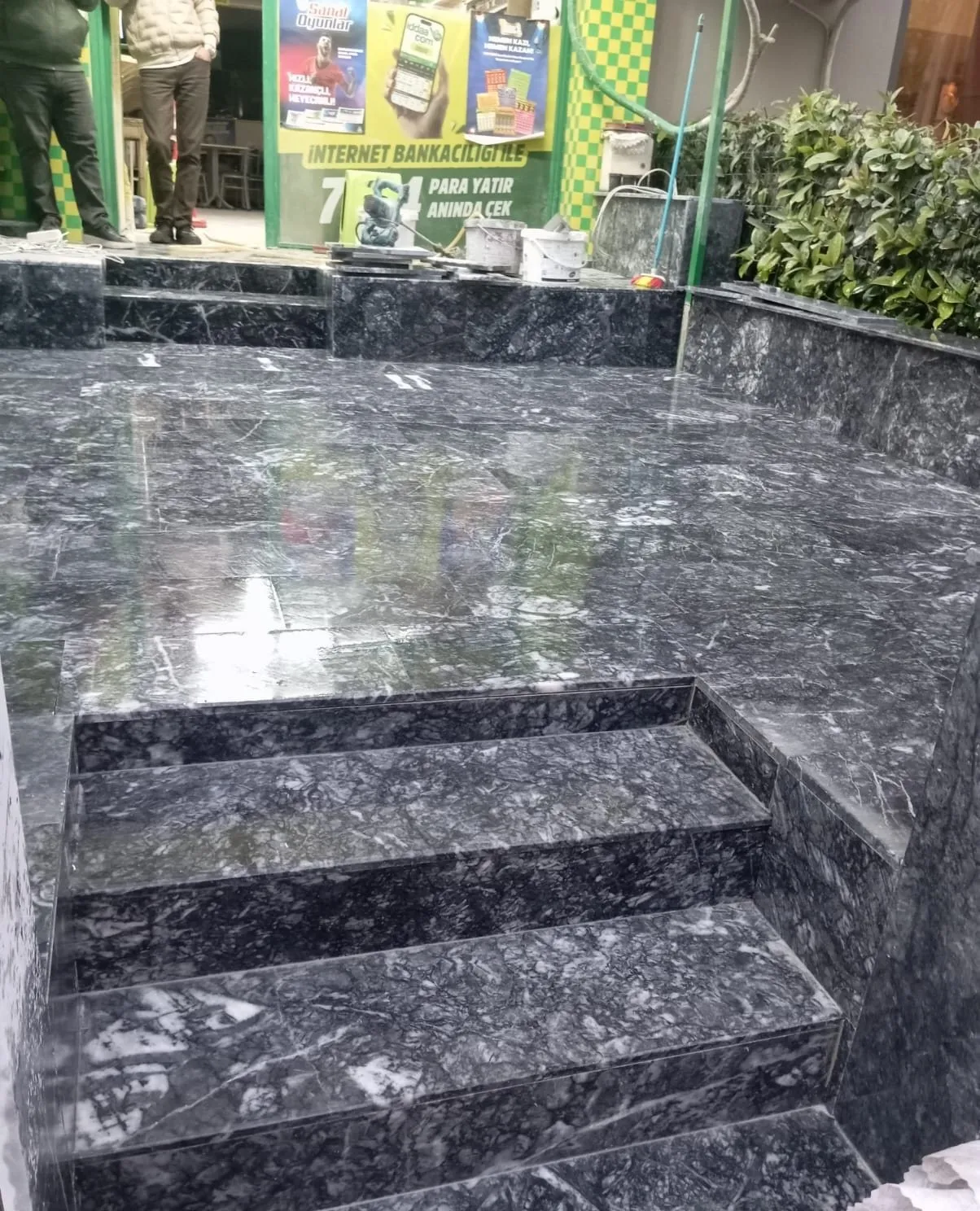 Dükkân önünde koyu mermer desenli merdiven ve teras kaplaması
